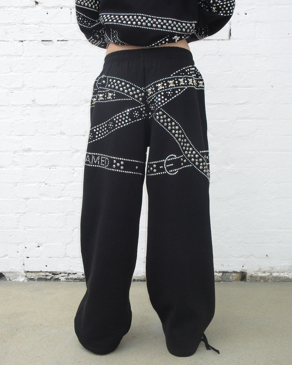 Back view of model wearing Crush studded belt oversized sweatpants black.
