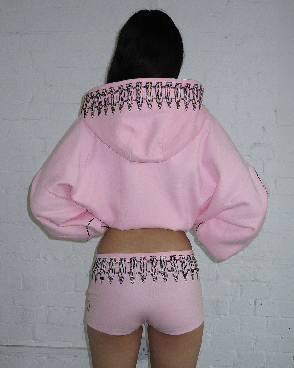Back View Of Model Wearing Baby Pink Rhinestone Crop Zip Hoodie by Named Collective.