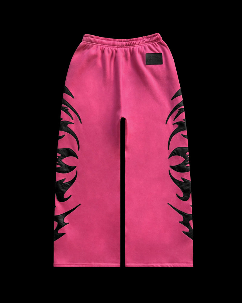 FLAME SWEATPANTS PINK POISON by NAMED collective, pink wide-leg pants with black applique patches, shown flat on black.