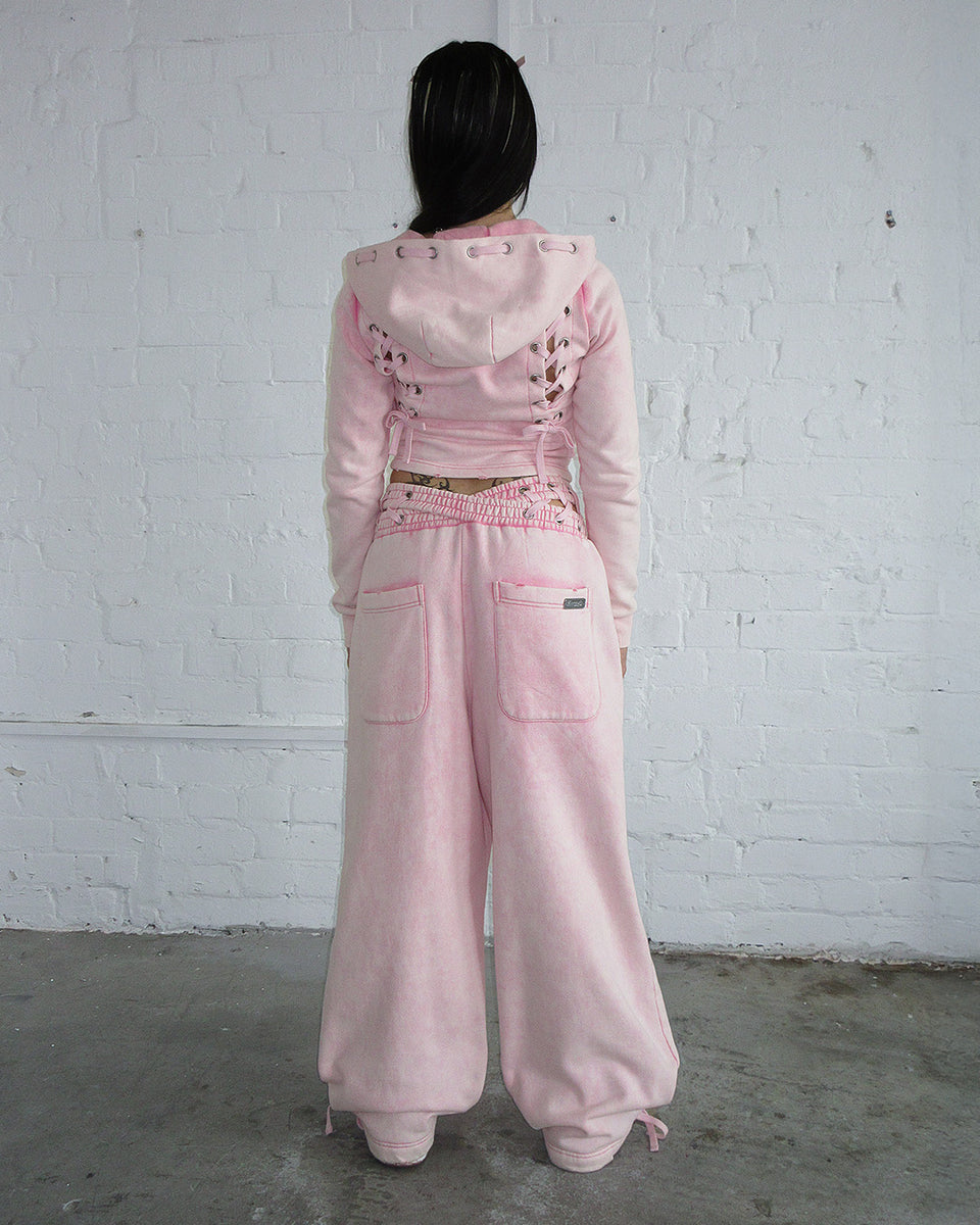 Vendetta oversized sweatpants in washed baby pink, featuring a cross-over waistband and made from organic cotton and recycled fleece.