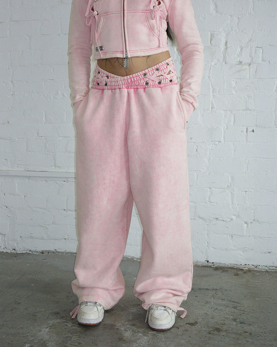 Vendetta oversized sweatpants in washed baby pink with cross-over waistband made from organic cotton and recycled polyester fleece.